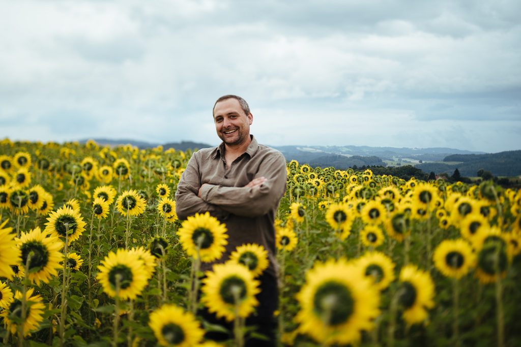Landwirt Volker Bertsche steht in einem Sonnenblumenfeld